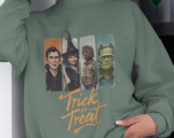 May include: Sage green sweatshirt featuring a Halloween-themed graphic. The graphic includes illustrations of classic monsters and the text "Trick or Treat" in orange. The sweatshirt is made of a soft material and has a crew neck.