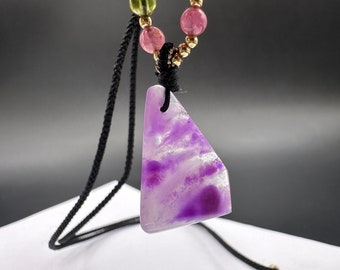May include: A purple and white stone pendant necklace with a black cord and a multi-colored beaded chain. The beads are green, pink, and gold.