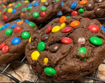 Könnte beinhalten: Nahaufnahme von Schokoladen-Chip-Cookies, die mit bunten M&M's-Bonbons belegt sind. Die Kekse sind auf einem Gitterrost angeordnet.