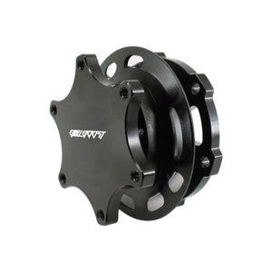 Puede incluir: Buje de liberación rápida para volante de metal negro con un diseño de estrella de seis puntas y la palabra "WILLROOST" impresa en la cara.