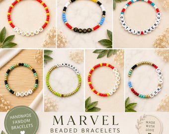 Puede incluir: Colección de pulseras de cuentas con nombres de personajes como "Iron Man", "Thor" y "Captain America". Cada pulsera presenta cuentas de colores y cuentas de letras blancas. La imagen también incluye el texto "Marvel Beaded Bracelets".