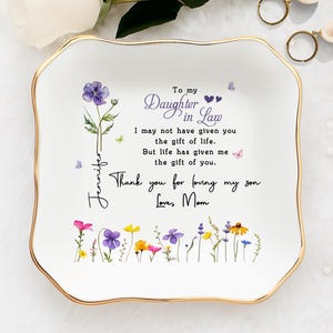 Peut inclure: Un ensemble de trois mugs en céramique avec un glaçage moucheté de couleur crème. Chaque mug présente un motif peint à la main différent : une feuille bleue et verte, une fleur jaune et une baie rouge. Les mugs ont un design simple et moderne.