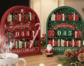 May include: Two festive wooden bookshelves, one red and one green, each with a number display. The red shelf shows "044" and the green shelf shows "045". Both are decorated with miniature books and the text "BOOKS READ THIS YEAR" and "SOPHIA'S LIBRARY".