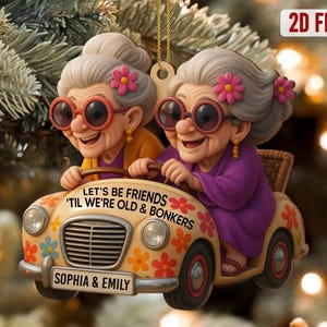Può includere: Un ornamento stravagante con due donne anziane in un'auto d'epoca. L'auto è decorata con motivi floreali e la scritta "LET'S BE FRIENDS 'TIL WE'RE OLD & BONKERS". La targa recita "SOPHIA & EMILY".