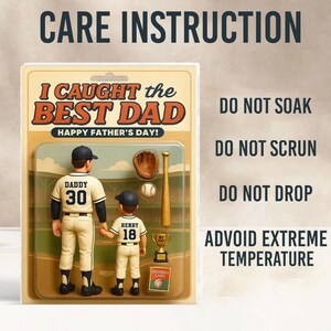 May include: A Father's Day gift set featuring two baseball figures, a glove, a bat, a baseball, and a trophy. The text reads "I Caught the Best Dad" and "Happy Father's Day!" Care instructions are also included.
