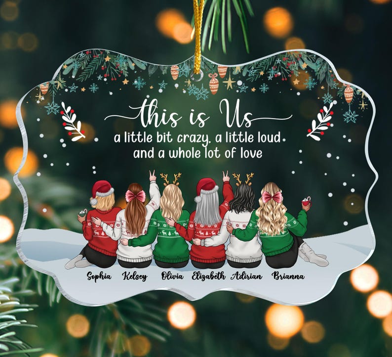 May include: A clear acrylic Christmas ornament with a festive design. The ornament features six figures in sweaters, with the text "this is Us" and the phrase "a little bit crazy, a little loud, and a whole lot of love." Names are printed below the figures.