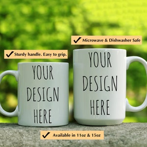 May include: Two white ceramic mugs with black text that reads "YOUR DESIGN HERE". The mugs are microwave and dishwasher safe and available in 11oz and 15oz sizes.