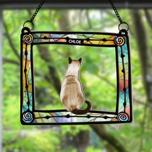 May include: A stained glass window hanging with a colorful frame and a cat silhouette inside. The cat is facing away from the viewer and the name "CHLOE" is written at the top of the frame.