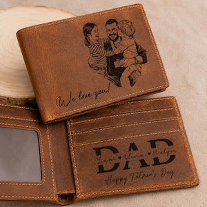 May include: Brown leather wallet with a picture of a man and two children engraved on the front. The text "We love you!" is also engraved. The inside of the wallet reads "DAD" with names and "Happy Father's Day".