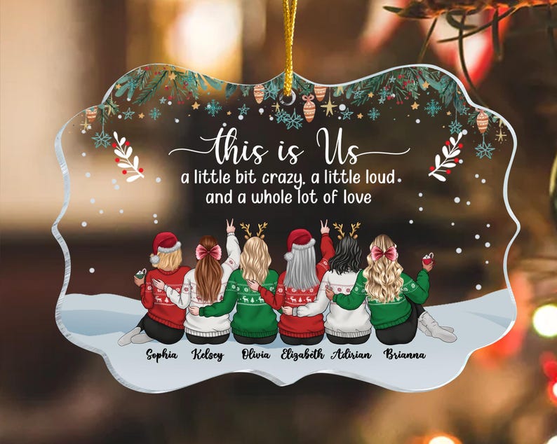 May include: Clear acrylic ornament with a festive design. The ornament features six figures wearing sweaters and Santa hats, with the text "this is Us" and the names Sophia, Kelsey, Olivia, Elizabeth, Adirian, and Brianna.