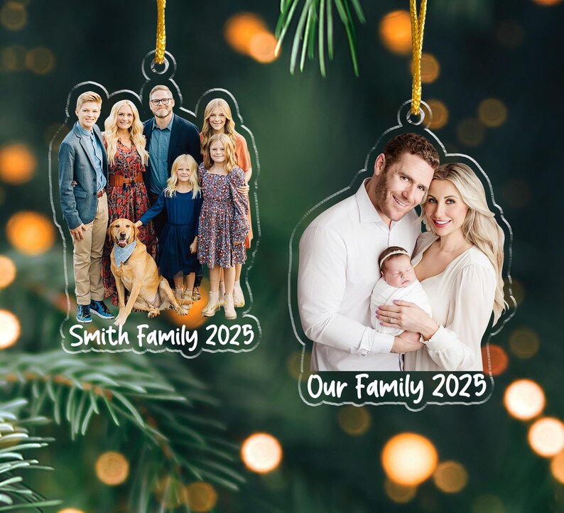 Pu&ograve; includere: Due ornamenti fotografici familiari in acrilico trasparente con cordini dorati. Uno presenta una famiglia con un cane, il testo "Smith Family 2025". L'altro mostra una famiglia con un bambino, il testo "Our Family 2025".