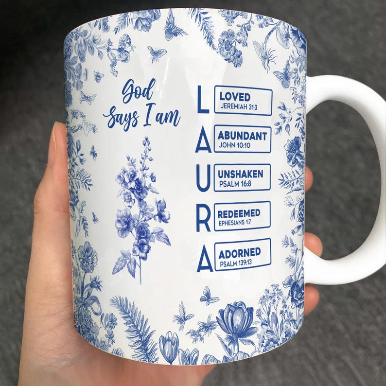 Pu&ograve; includere: Tazza in ceramica bianca con un motivo floreale blu e le parole "Dio dice che io sono" e il nome "LAURA". La tazza presenta anche le parole "AMATO", "ABBONDANTE", "INCROLLABILE", "REDENTO" e "ADORNATO".