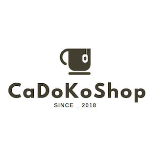 K&ouml;nnte beinhalten: Ein schwarz-wei&szlig;es Logo f&uuml;r einen Tee-Laden namens "CaDoKoShop" mit dem Slogan "SINCE_2018". Das Logo zeigt ein stilisiertes Bild einer Teetasse mit einem Teebeutel.