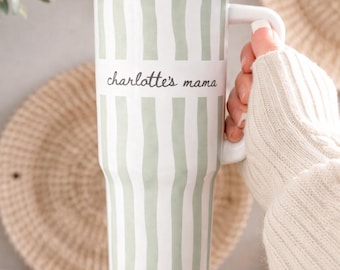 Puede incluir: Vaso blanco con un patrón de rayas verdes y una tapa negra. El vaso tiene un asa blanca y una pajita. El texto "charlotte's mama" está impreso en la parte delantera.