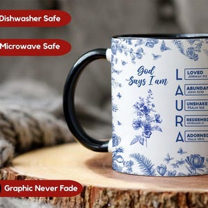 Pu&ograve; includere: Tazza in ceramica bianca con manico e bordo neri, con disegni floreali blu e la scritta "Dio dice che io sono". Il nome "LAURA" &egrave; scritto verticalmente con parole ispiratrici e versetti biblici. Lavabile in lavastoviglie e microonde.