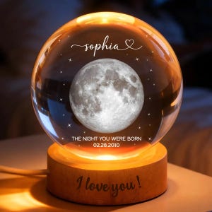 May include: A glowing crystal ball with a detailed moon image inside, resting on a wooden base. The text "sophia" and "I love you!" are inscribed. The date "02.28.2010" is also visible.