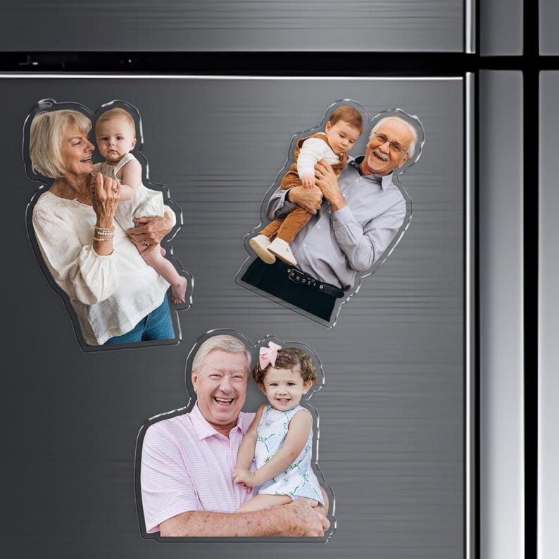 Pu&ograve; includere: Tre calamite trasparenti in acrilico con foto di famiglia. Ogni calamita mostra una persona diversa che tiene in braccio un bambino o un bambino piccolo. Le foto sono ritagliate a forma delle persone nell'immagine, creando un look unico e personalizzato.
