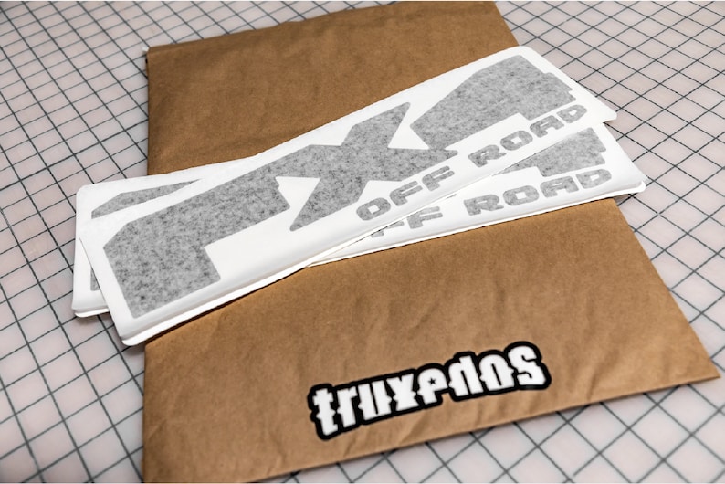 May include: Three gray vinyl decals with the text "FX4 OFF ROAD" on a brown paper envelope with the text "TRUXPEDOS" on the bottom.