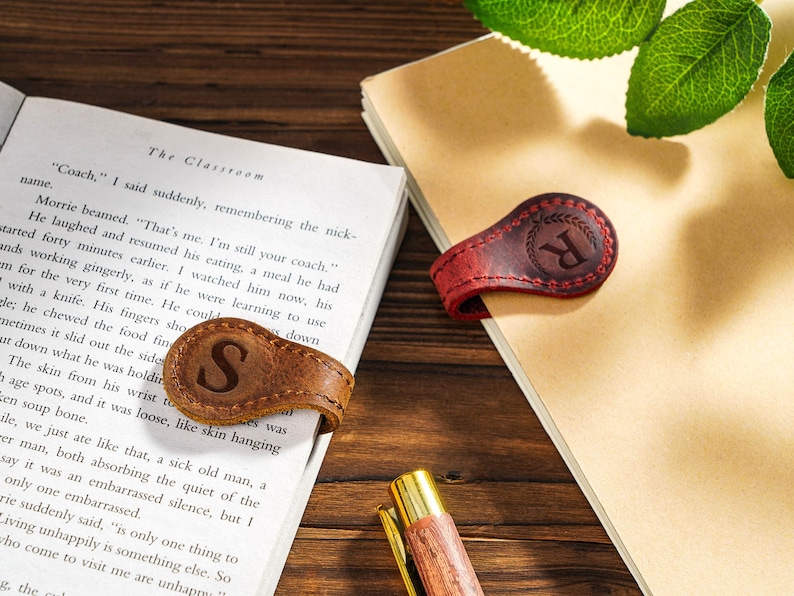 May include: Two leather book marks with magnetic closures. One is brown with the letter "S" and the other is red with the letter "R".