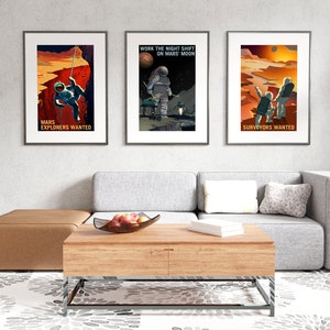 May include: Three framed posters with a Mars theme. The posters feature astronauts in space suits and the text "Mars Explorers Wanted", "Work the Night Shift on Mars Moon", and "Surveyors Wanted".