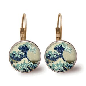 May include: A pair of gold-toned hoop earrings with a round glass cabochon featuring a print of The Great Wave off Kanagawa by Katsushika Hokusai.