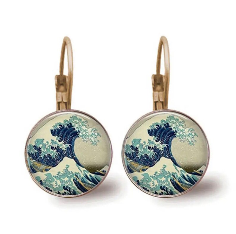 May include: A pair of gold-toned hoop earrings with a round glass cabochon featuring a print of The Great Wave off Kanagawa by Katsushika Hokusai.
