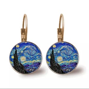 May include: A pair of silver hoop earrings with a round glass charm featuring a painting of Vincent van Gogh's "Starry Night".