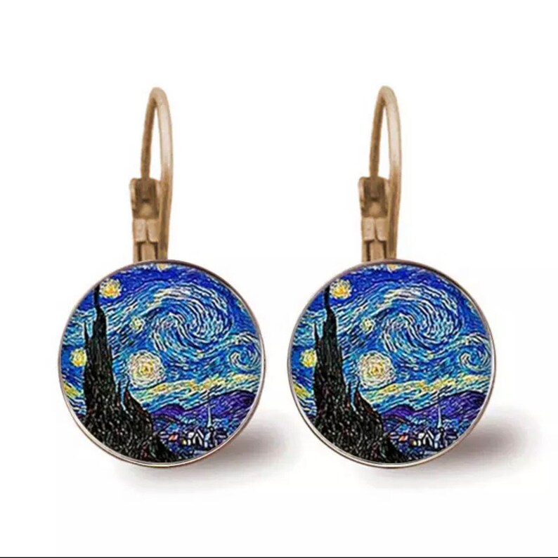 May include: A pair of silver hoop earrings with a round glass charm featuring a painting of Vincent van Gogh's "Starry Night".