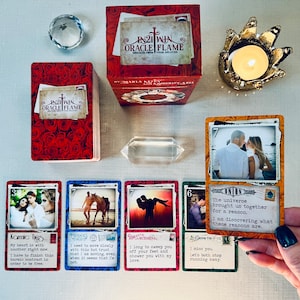 May include: A set of oracle cards with colorful backgrounds and images. The cards feature messages about love, trust, and growth. The cards are part of the 21 Win Oracle Flame deck.