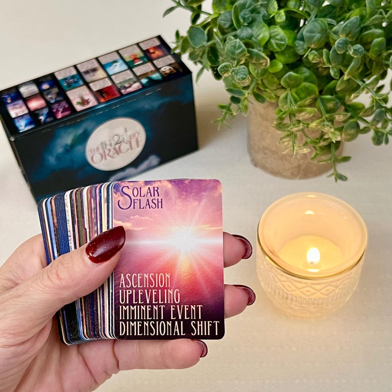 K&ouml;nnte beinhalten: Ein Deck Orakelkarten mit einer herausgezogenen Karte in Lila, Rosa und Orange. Die Karte lautet "Solar Flash" und hat den Text "Aufstieg, Level-Up, Bevorstehendes Ereignis, Dimensionale Verschiebung".