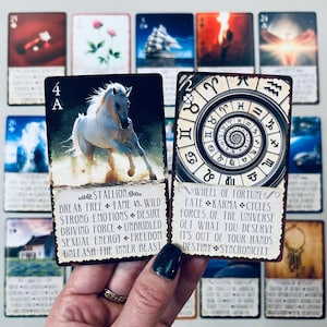 K&ouml;nnte beinhalten: Zwei Tarotkarten, eine mit einem wei&szlig;en Pferd, das an einem Sandstrand rennt, und dem Text "Stallion" und die andere mit einem kreisf&ouml;rmigen Design und dem Text "Wheel of Fortune".
