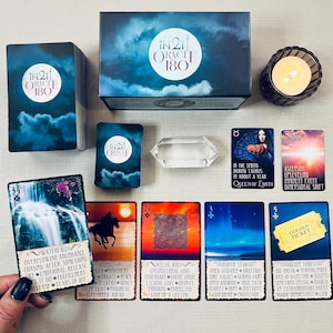 May include: A set of 180 oracle cards with a blue, purple, and white color scheme. The cards feature illustrations of nature, animals, and celestial bodies. The box is labeled "In2it Oracle 180".