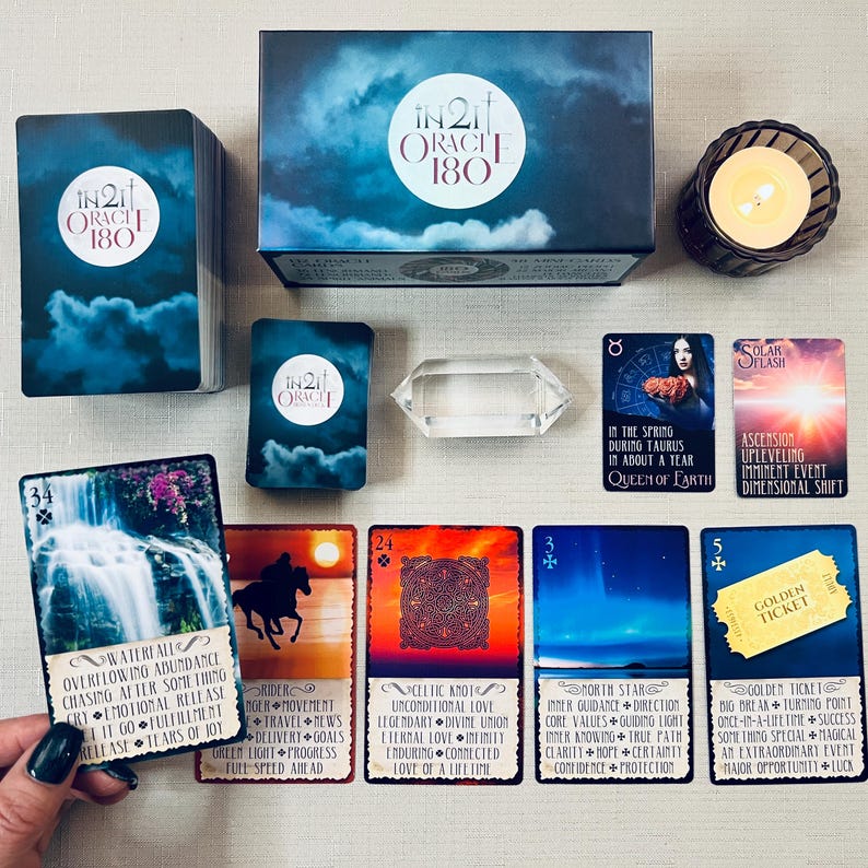 May include: A set of 180 oracle cards with a blue, purple, and white color scheme. The cards feature illustrations of nature, animals, and celestial bodies. The box is labeled "In2it Oracle 180".