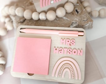 May include: A wooden desk organizer with a pink sticky note pad, a pink pen, and a pink rainbow with hearts. The organizer has the text "MRS WATSON" on it.
