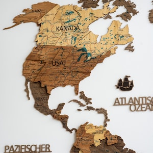 May include: A wooden world map with detailed country outlines and labels, including "KANADA", "USA", and "MEXICO". The map features varying shades of brown and tan, with text labels in a serif font. A ship silhouette is also present.