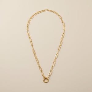 Halsband med gem i 18k guld och klicklås – silhuetten alla känner till. En detalj ingen förväntar sig.