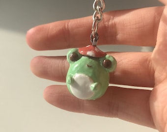 PRE ORDER (not officially for sale, the price is subject to change upon the product&#39;s official release) Frog with mushroom hat clay keychain