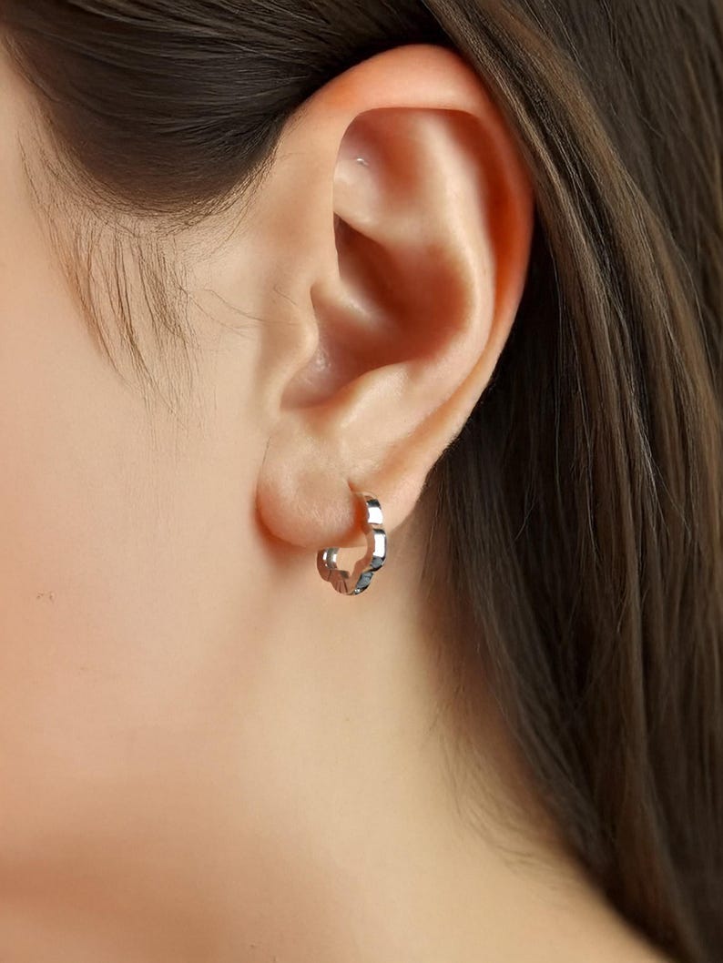 These platinum hoop earrings showcase a modern floral-inspired design, blending soft petal-like curves with a sleek geometric edge. Crafted in premium platinum, they radiate understated elegance while remaining durable for everyday wear. Lightweight and versatile, they effortlessly complement both casual and formal outfits. A refined expression of timeless style, these earrings make a graceful addition to any jewellery collection.