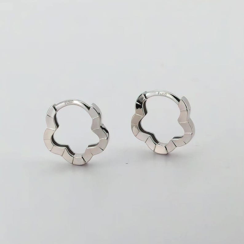 These platinum hoop earrings showcase a modern floral-inspired design, blending soft petal-like curves with a sleek geometric edge. Crafted in premium platinum, they radiate understated elegance while remaining durable for everyday wear. Lightweight and versatile, they effortlessly complement both casual and formal outfits. A refined expression of timeless style, these earrings make a graceful addition to any jewellery collection.