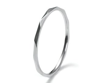 May include: A silver ring with a faceted, geometric design. The ring is simple and modern.
