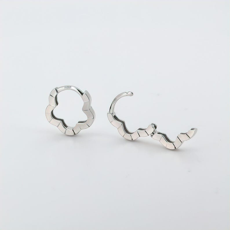 These platinum hoop earrings showcase a modern floral-inspired design, blending soft petal-like curves with a sleek geometric edge. Crafted in premium platinum, they radiate understated elegance while remaining durable for everyday wear. Lightweight and versatile, they effortlessly complement both casual and formal outfits. A refined expression of timeless style, these earrings make a graceful addition to any jewellery collection. Lever Back Earrings