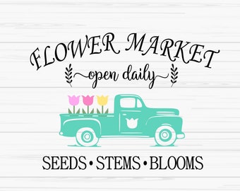 May include: A turquoise pickup truck with a bed full of pink, yellow, and white tulips. The truck has the words "FLOWER MARKET open daily" above it and "SEEDS STEMS BLOOMS" below it.