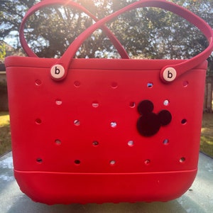 May include: Red tote bag with a black Mickey Mouse head design. The bag has a white "b" on each handle.