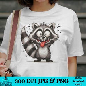 May include: White t-shirt with a cartoon raccoon with a long tongue sticking out. The raccoon has black and white stripes on its tail and is wearing a mischievous expression. The text "300 DPI JPG & PNG" is at the bottom of the image.