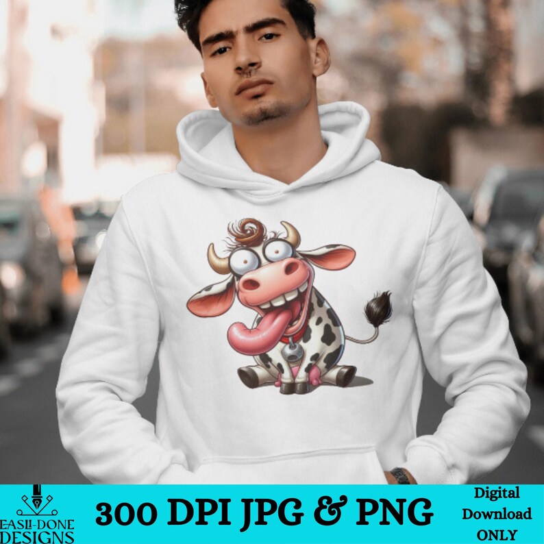 May include: A white hoodie with a cartoon image of a cow with a big tongue sticking out. The cow is black and white with a pink nose and a bell around its neck.
