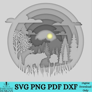 Könnte beinhalten: Ein digitales Papierbastel-Design mit einem Bären in einer Waldszene mit Bäumen, Bergen und einer Sonne. Das Design ist geschichtet und hat einen 3D-Effekt. Das Design ist in den Formaten SVG, PNG, PDF und DXF verfügbar.