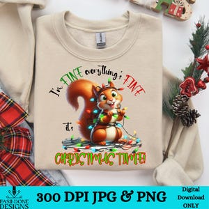 May include: A beige sweatshirt with a cartoon squirrel tangled in Christmas lights. The text on the sweatshirt reads "I'm FINE everything's FINE it's CHRISTMAS TIME".