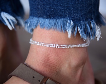 May include: A delicate white beaded anklet with a double row of small beads.