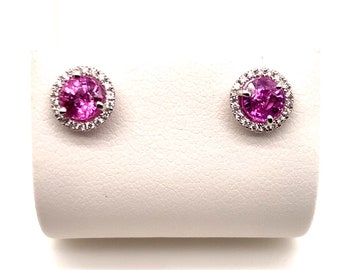 May include: A pair of silver earrings with pink gemstones surrounded by a halo of smaller diamonds.