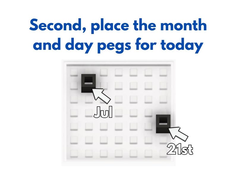 Może przedstawiać: Biały kalendarz z siatką małych kwadrat&oacute;w. U g&oacute;ry znajduje się tekst &bdquo;Second, place the month and day pegs for today&rdquo;. Na kalendarzu umieszczono dwa czarne kołki, jeden wskazujący &bdquo;Jul&rdquo;, a drugi &bdquo;21st&rdquo;.